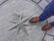 Manhole drain cover on streets with mans feet on it