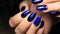 Manicure, cat`s-eye and blue stained glass gel polish with a picture and rhinestones