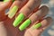 Manicure closeup. Woman bright green nails close-up. Nail care in beauty salon. Spa healthy treatments for female hands. Fashion