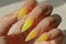 Manicure closeup. Woman yellow nails close-up. Nail care in beauty salon. Spa healthy treatments for female hands. Fashion bright