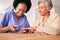 Manicure, elderly woman and nurse in retirement cut nails on table for spa day, selfcare and wellness. People, smile and