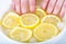 Manicure. Lemon juice, natural cosmetics. The woman soaking fingernails in lemon juice water