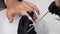 A manicure master gives a manicure to a girl in the salon. Nails are filled with a nail file. Close-up