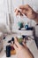 Manicure master table with tools for work. A girl holding a jar of cuticle oil with an electric nail file and nail polish in the