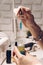 Manicure master table with tools for work. A girl holding a jar of cuticle oil with an electric nail file and nail polish in the