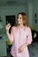 Manicure tools in hands of female manicurist wearing pink uniform in studio