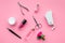 Manicure tools set for nail care on rose background top view