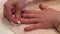 Manicure treatment in beauty salon. Woman removes varnish from nail