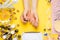 Manicure-work with nails, beauty care. Woman gets a manicure nails. Beautician puts nails to client, on yellow background