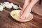 Manicured female feet in spa wooden bowl with flowers and water closeup