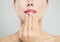 Manicured hand with french manicure and pink glossy lips. Woman face macro