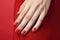 Manicured hand with red nail polish