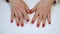 Manicured hands on table in beauty salon. Female finger with red nails knocking on table