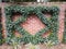 Manicured vine with green leaves on red brick wall