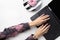 Manicured woman`s hands in trendy pink hoodie typing on laptop