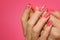 Manicured woman`s nails with pink nailart with flowers.