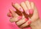 Manicured woman`s nails with pink nailart with flowers.