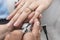 A manicurist applies a base layer coat to the pinky finger of a female customer