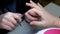 The manicurist applies a layer of gel polish to the nail with a brush