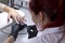 A manicurist applies a matte coating with a brush on the nails of a client of the salon.