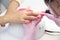 Manicurist apply nail Polish. Close-up of a woman applying nail Polish to her finger nails.Pink nails