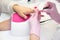 Manicurist apply nail Polish. Close-up of a woman applying nail Polish to her finger nails.Pink nails