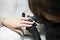 Manicurist applying gel polish on client`s nails. Master of manicure in black gloves makes a french manicure on the nails of a wom