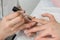 Manicurist applying a nail polish on the nails to strengthen and firm the keratin