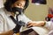 Manicurist with black protective mask work on a woman client hands, Professional works in gloves for sterility