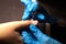 manicurist in blue gloves does a hardware manicure, mechanical processing of nails with a cutter, cuticle removal with an