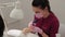 Manicurist cuts nails with a machine to a client in a manicure salon.