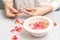 Manicurist decorates bowl with petals