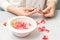 Manicurist decorates bowl with petals