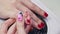 Manicurist delicately paints nails with a very thin brush