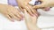 The manicurist disinfects the client`s hands. Manicure artist sterilize hand and nail for female in salon. Close-up Woman using