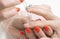 Manicurist dripping anti-inflammatory oil on the cuticles of the client`s fingers