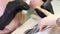 A manicurist files nails with a metal file. Manicure process in a beauty salon.