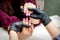 Manicurist holds pink female fingernails