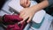 Manicurist holds spatula and lifts cuticle on nails of little and ring finger