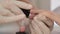 Manicurist master is applying pink gel on client nails in salon, hands closeup.