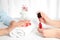 Manicurist painting client`s nails with bright polish in salon