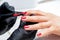 Manicurist paints fingernails by red nail polish