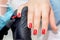 Manicurist paints nails of woman
