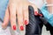 Manicurist paints nails of woman