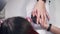 Manicurist paints a woman`s nails with colorless nail polish close-up