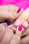 Manicurist polish nails on women`s hand in nail salon