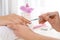 Manicurist preparing client`s fingernail cuticles in salon