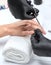 A manicurist removes cuticles during a nail extension procedure in a beauty salon. Professional hand care