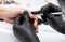 A manicurist removes cuticles during a nail extension procedure in a beauty salon. Professional hand care