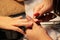 Manicurist at training courses shows students how to handle nails with the help of nippers cuticles before applying